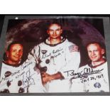 A signed colour photograph of the Apollo 11 crew, captured posing together in their space suits,