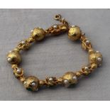 A precious yellow metal, emerald and pearl bracelet, formed from alternating spherical and open work