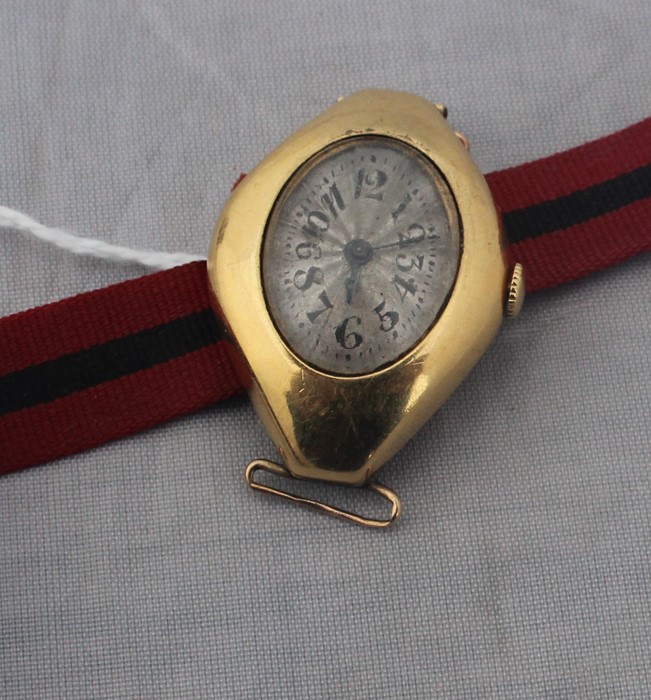 An 18ct. gold ladies' wrist watch, c.1953, manual movement, having engine turned and silvered Arabic