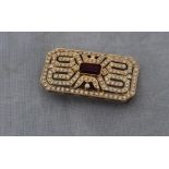 An 18k yellow gold, diamond and ruby geometric brooch, in the Art Deco taste, the pierced