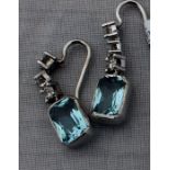 A pair of precious white metal, diamond and aquamarine drop earrings, each having three links claw