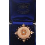 A 14ct. rose gold and pearl target brooch, having raised textured disc claw set pearl to centre,