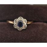 An 18ct. gold, sapphire and diamond ring, having oval cut sapphire surrounded six rose cut