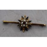 A 9ct. gold, pearl and ruby "star" bar brooch, having niello work eight pointed star below gold