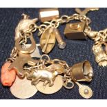 A yellow metal charm bracelet, suspending numerous 9ct. gold charms, the chain formed from