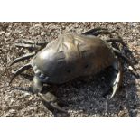 An early 20th bronzed crab with glass eyes, the hinged top reveals circular storage