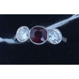 A white metal, diamond and ruby ring, set central round cut ruby with round brilliant cut diamond to
