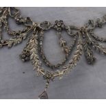 A Belle Epoque white metal and diamond set choker swag fringe necklace, having three leaf and flower