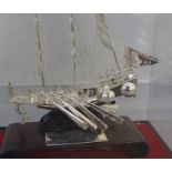 A Chinese white metal model sailing junk warship, having three masts, their sails unfurled, with