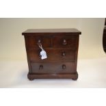 A Victorian flame mahogany miniature chest of drawers, turned pulls, bun feet, height 23cm, width