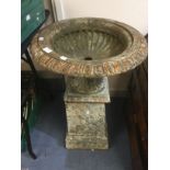 A pair of late 19th Century cast iron garden pedestal urns, raised on plinth bases (2)