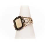A 9ct gold mourning ring, swivel top hair compartment, open work shoulders, with inscription 'Mary