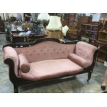 A mid Victorian Carved Mahogany Settee, c.1870, pink upholstery raised on turned supports on