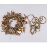 A 9ct gold charm bracelet with various 9ct gold and unmarked yellow metal charms, including