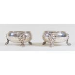 A pair of George II Baroque silver circular salts, gadroon rim above bodies engraved with panels