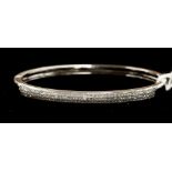 A diamond set 18ct white gold bangle, comprising three rows of princess cut diamonds set to the