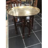 Middle Eastern metal tea table on folding decorative wooden legs.