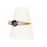 A sapphire and diamond three stone ring, the central round sapphire claw set with illusion set