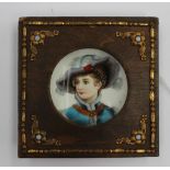 A porcelain hand painted miniature portrait, having a wooden surround and gilt mounts. Size 10.5cm.