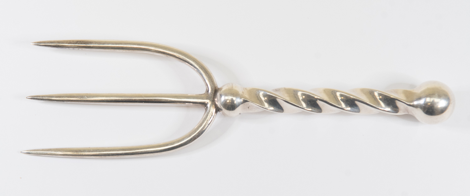 A white metal three prong meat or bread  fork with barley twist handle