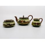A three piece Watcombe ware tea service. Teapot , sugar bowl and milk jug. Teapot having a plated
