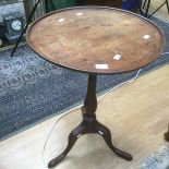 A George III mahogany circular topped tripod wine table, having a dished circular top