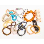 A collection of approximately eighteen various elasticated semi-precious bead bracelets, including