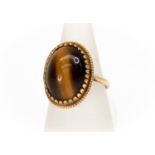 A large oval tigers eye with fancy 9ct gold rope border, setting approx 20mm x 15mm, size N, total