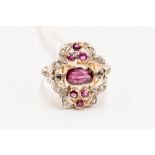 A ruby and diamond dress ring, 14ct gold, open work design set to the centre with a elongated