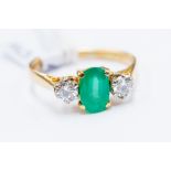 An emerald and diamond set ring, the claw set oval emerald approx 0.80ct, with brilliant cut