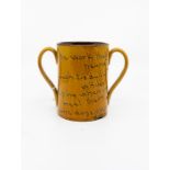 A mid 19th Century loving cup, impressed H.M. Exeter, Slip ware and inscribed verse, old chip to