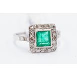 An emerald and diamond ring, the central square cut emerald weighing approx 0.85ct, set withing a