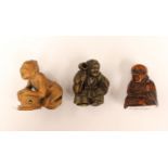 Three Japanese netsukes, one seated man in boxwood with protruding snake in box, Hoti woman in Rhino