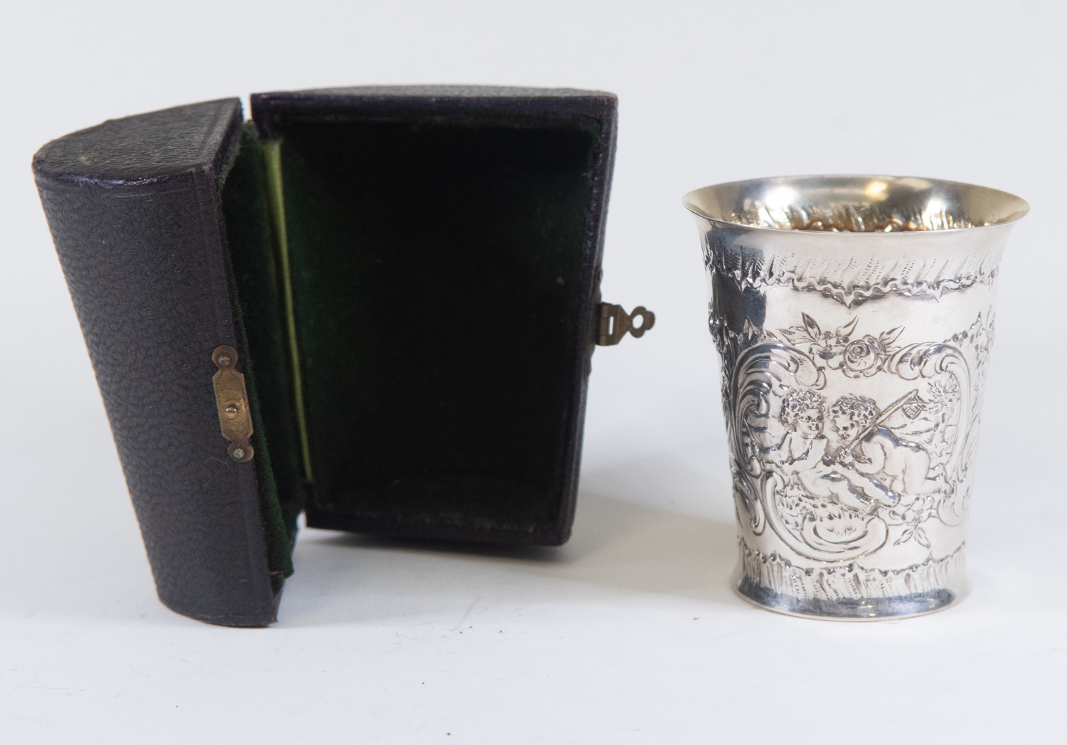 A German silver beaker in a leather travel case embossed cherub pattern gilt interior 800 stamped