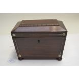 A Regency small rosewood tea caddy of sarcophagus form, side handles, bun feet