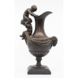 A bronze figural ewer on a marble base, the handle in the form of two putti, the quarter reeded body