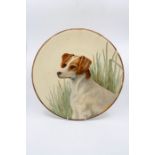 An Art Pottery painted charger of a Jack Russel Terrier, signed to the reverse C Bainbridge