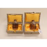 A pair of Chinese snuff bottles, boxed, intricately depicting town and country scenes