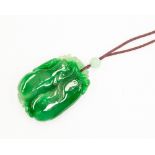 A carved jade pendant, with cord necklace, size approx 55mm x 37mm, total gross weight approx 53gms