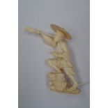 An early 20th century Japanese ivory okimono of a fisherman with spear and basket at feet, 11.5