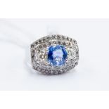 A  sapphire and diamond cluster ring, the cushion cut sapphire weighing approx 2.29 carats,