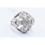 A diamond set cluster ring, openwork boule head setting, scroll and foliate decoration set with gain