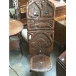 An Early 20th Century African carved two piece wooden chair, with hunt designed carving