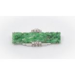 An Art Deco 18ct white gold jadeite and diamond set brooch, the rectangular plaque carved and