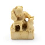 A 19th Century oriental ivory netsuke, carved as a disgruntled man with his arm on a table, height