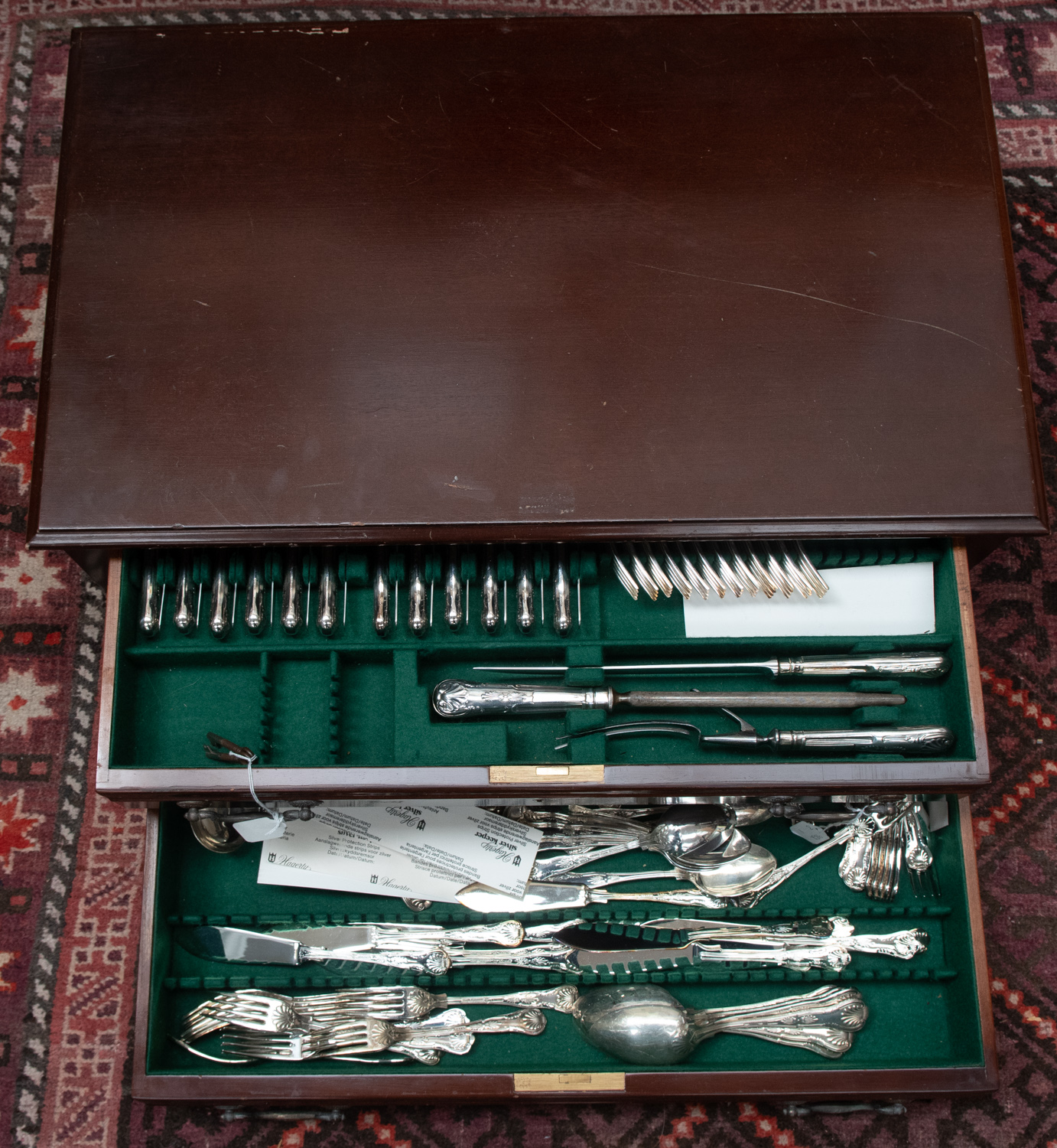 A canteen of silver plated King pattern cutlery and flatware, in a two drawer George II style lowboy