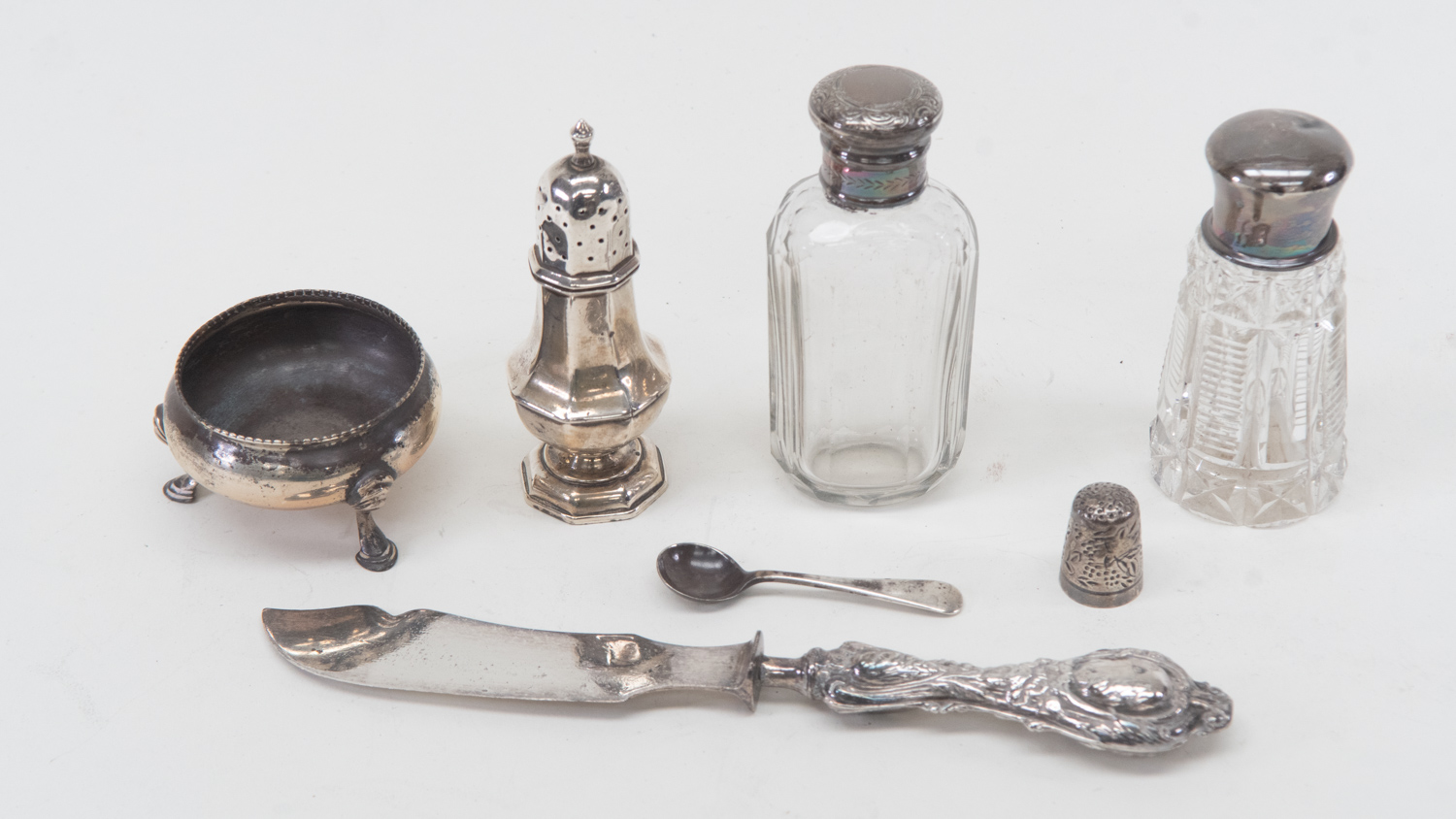Silver topped glass dressing table bottles, pepper pot, salt, thimble and silver handled butter
