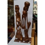 A pair of carved African figures of unusual striking design; one a group of heads and limbs, the