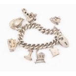 A silver charm bracelet, various charms, including a cat and fish, old boot with people inside,