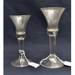 Two 18th century wine glasses, the bell shaped bowls with basal tear, on plain stems and conical